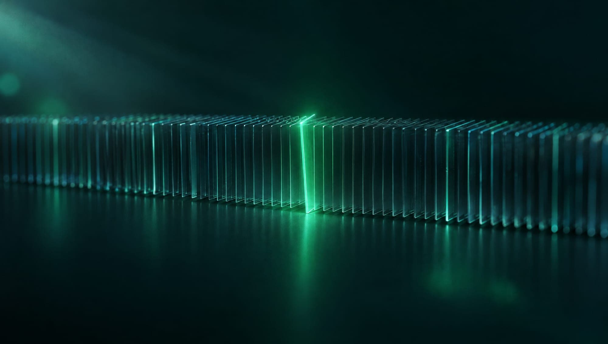 A row of thin glass slices with a single slice lit green and out of line